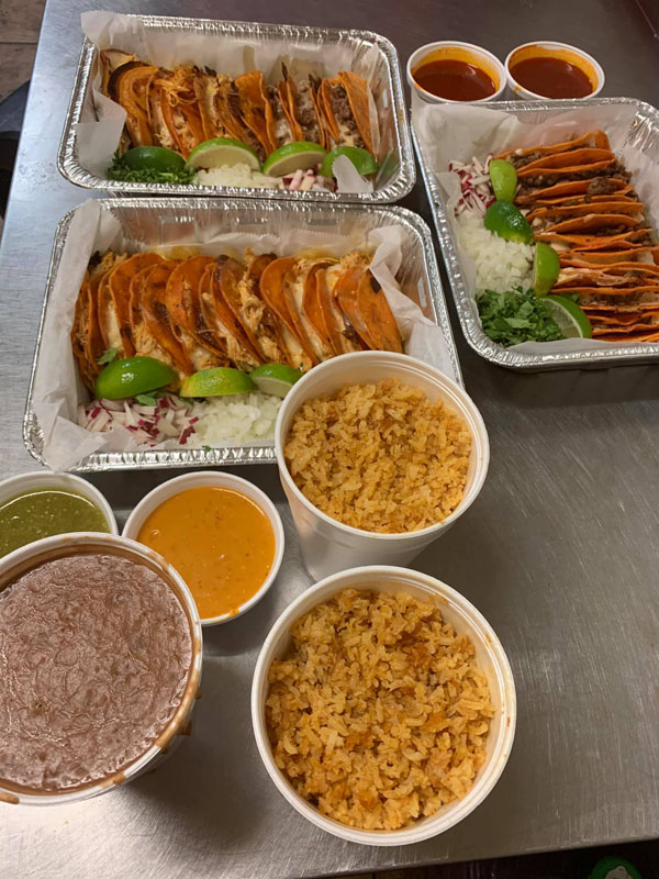 Catering tray of birria tacos with sides and consome
