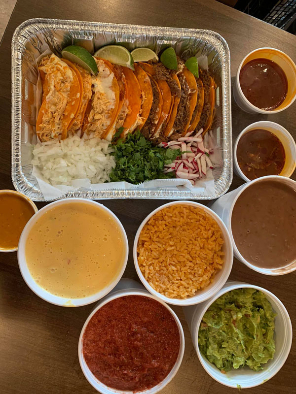 Catering tray of tacos and assorted sides